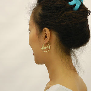 Model wearing personalized 14K gold 2mm tube name hoop earrings with secure hinged snap closure