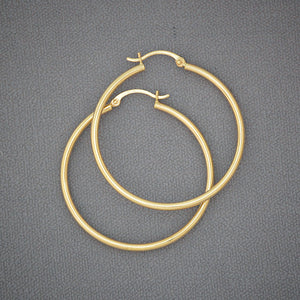 Pair of 14K yellow gold 1.5-inch round hoop earrings with a 2mm hollow tube design