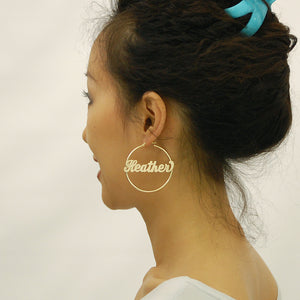 Close-up of 14k gold personalized name hoop earring showing custom cursive script and hinged snap closure
