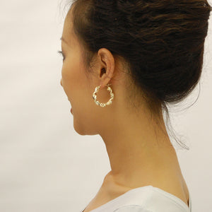 Model wearing 10K yellow gold 6mm twisted hoop earring showing 1.6 inch size fit