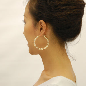 Model wearing 2 3/8 inch 10k yellow gold 6mm thick twisted hoop earrings