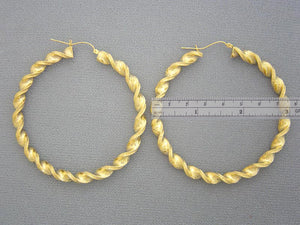 Hinged snap closure detail on 10K gold twisted hoop earring