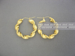 Close-up of hinged snap latch closure on 10K yellow gold 8mm twisted hoop earring