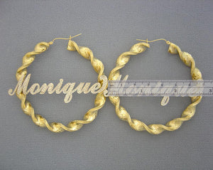 Close-up of two-tone personalized iced out letters on 8mm gold twisted hoop earrings