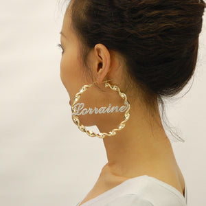 Model wearing 3-inch custom 10k gold twisted hoop earring with iced name