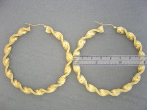 Close-up of secure clip-back clasp on 8mm hollow 10k gold twisted hoop earring