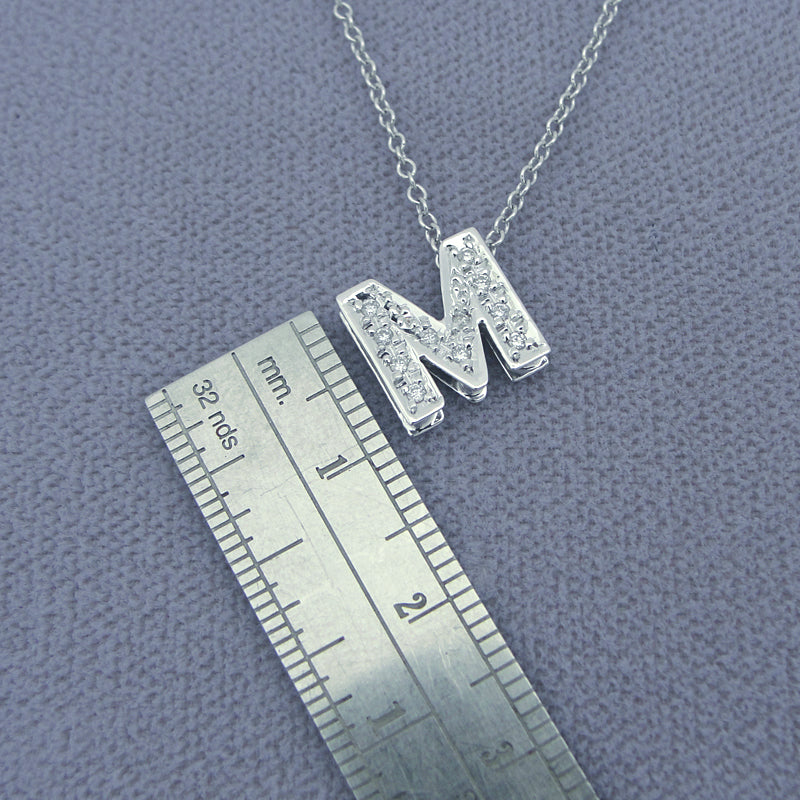 Close-up detail of genuine pave diamonds set in solid gold letter M pendant