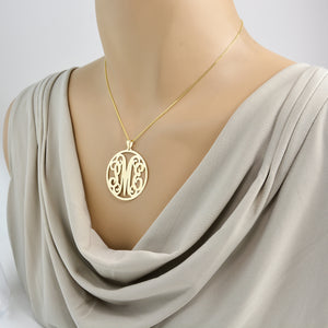 Solid gold custom monogram necklace on a gold rolo chain on mannequin
