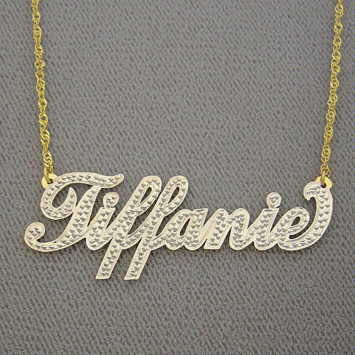 Gold name necklace with &#39;Tiffanie&#39; on a gray background