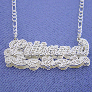 Model wearing a custom sterling silver 3D name pendant necklace with genuine diamond accents on a silver chain.