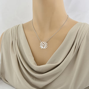 Woman wearing 1-inch custom sterling silver monogram necklace showing pendant size and placement