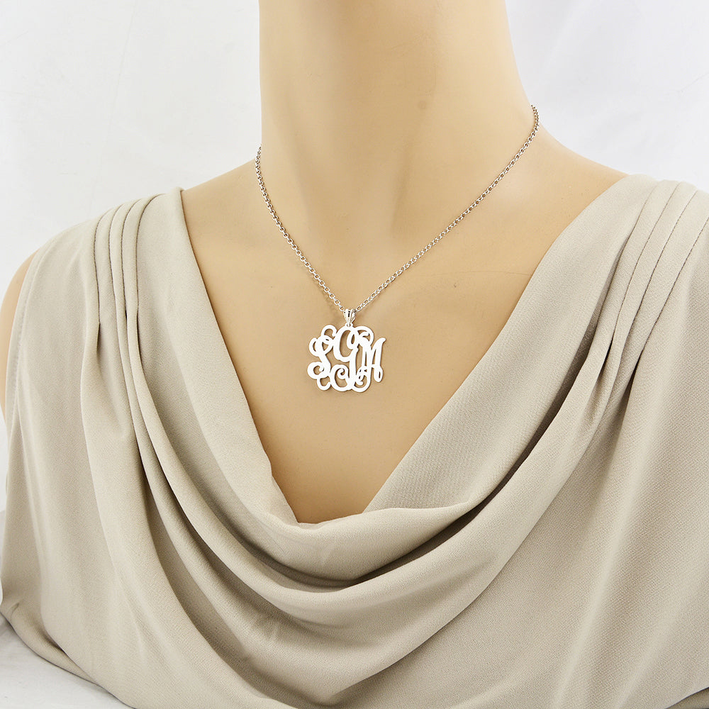 Model wearing a personalized sterling silver 3-initial monogram pendant on a fine silver chain.