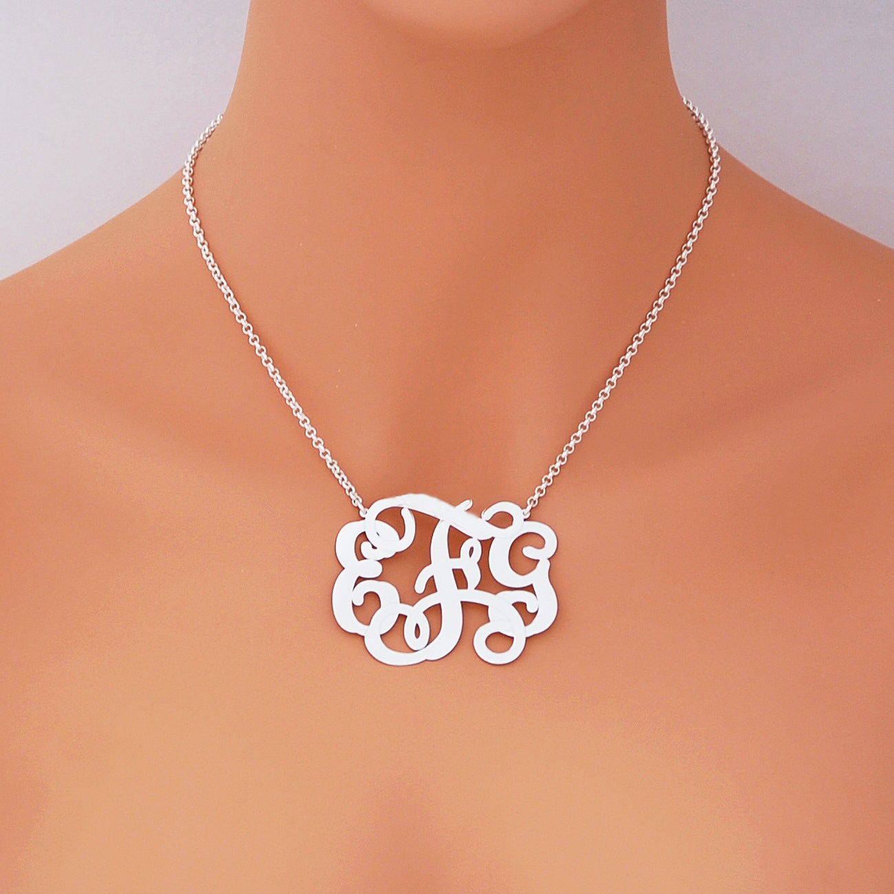 Woman wearing custom sterling silver 3-initial monogram pendant necklace
