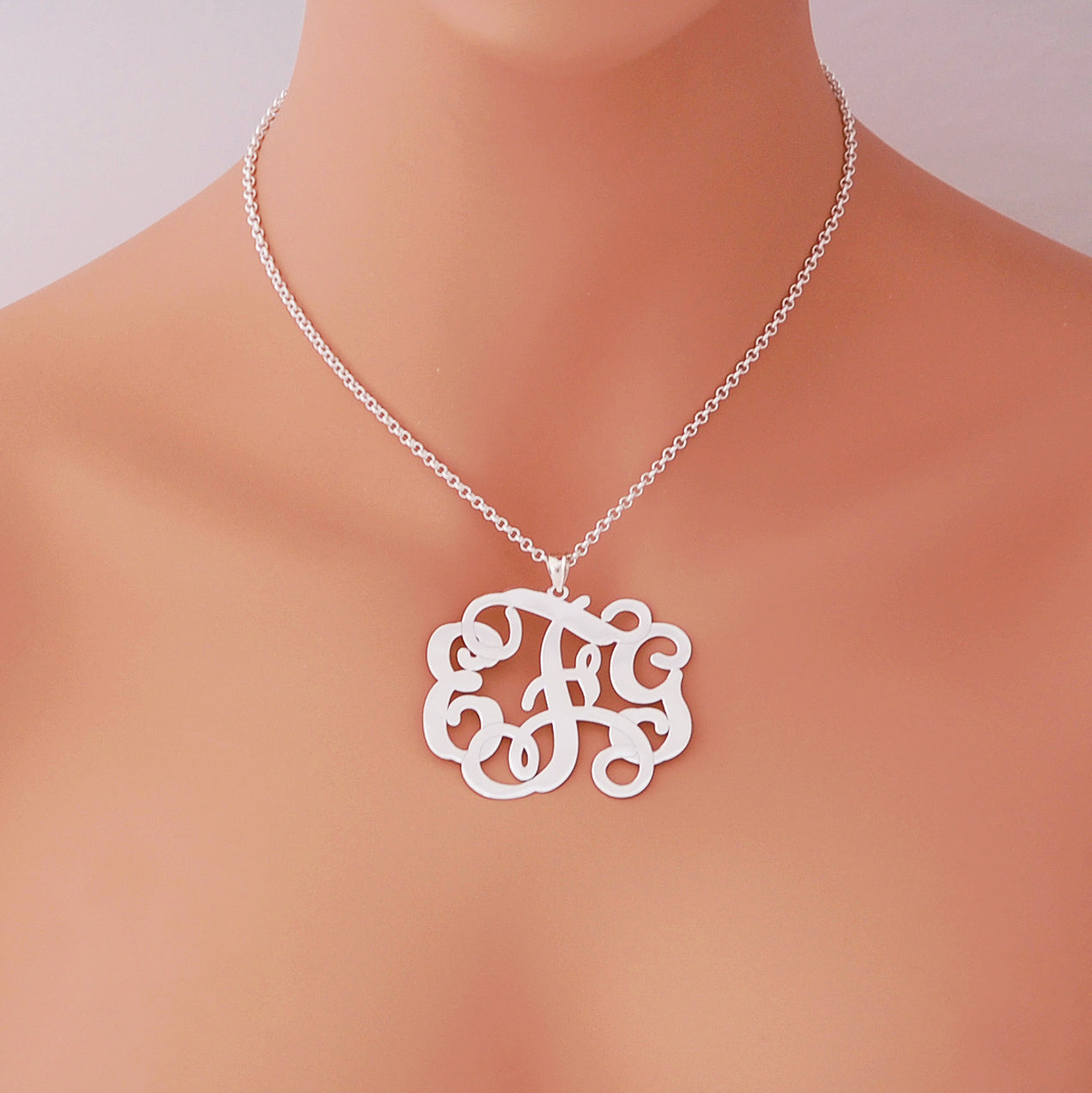 Woman wearing a personalized sterling silver 3-initial monogram pendant necklace