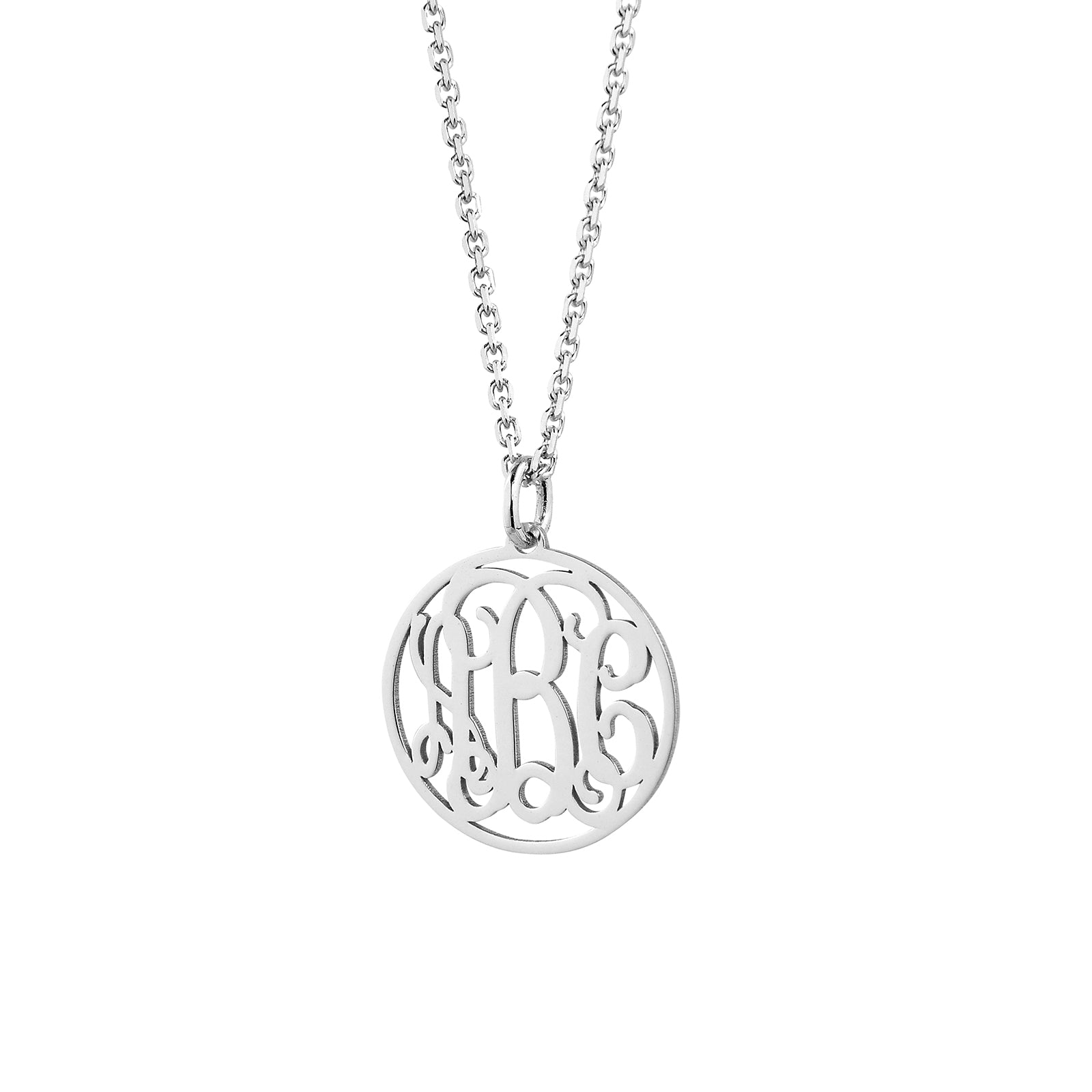 Close-up of laser-cut sterling silver circle monogram pendant showing intricate initial detail