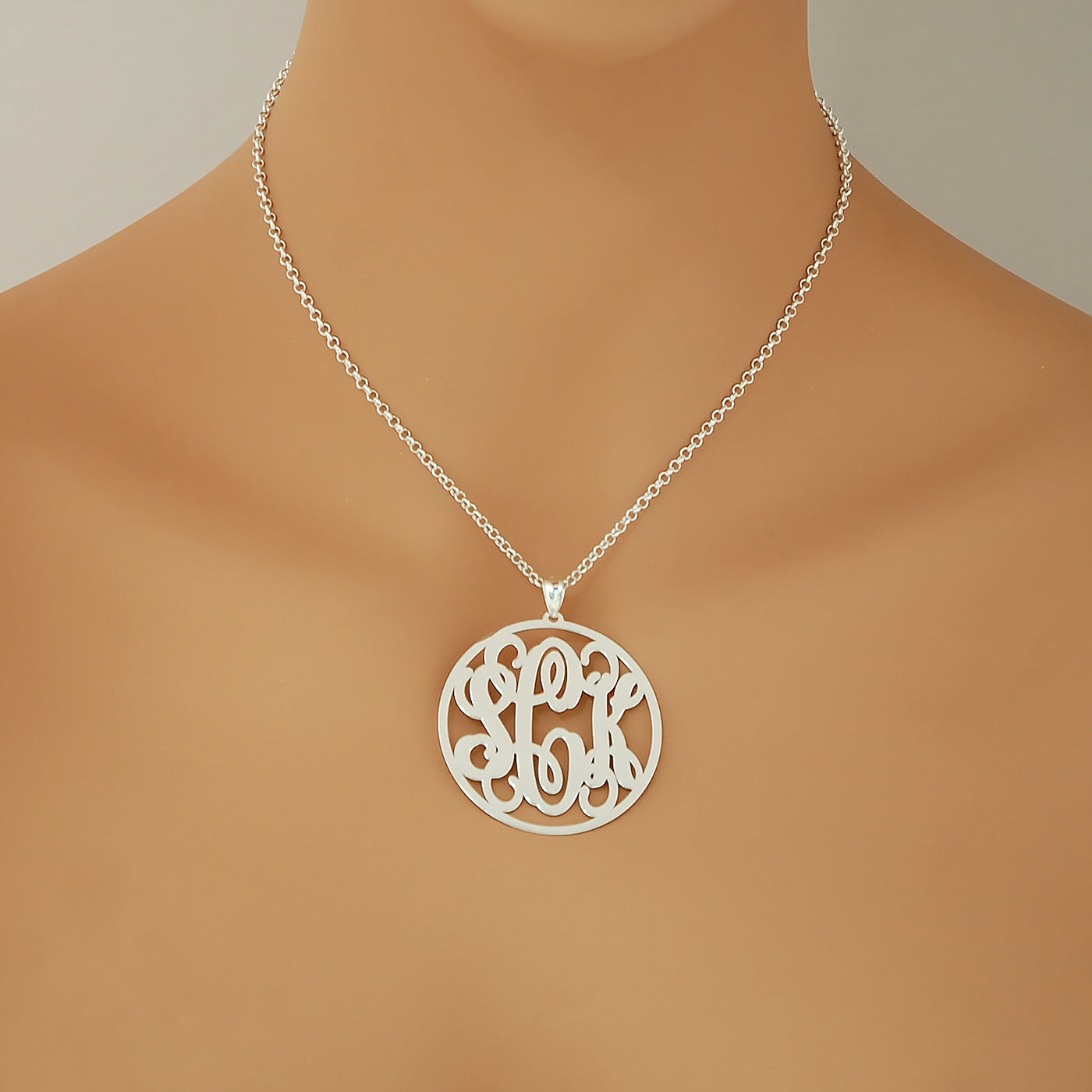 Woman wearing a personalized 1.75-inch sterling silver circle monogram necklace.
