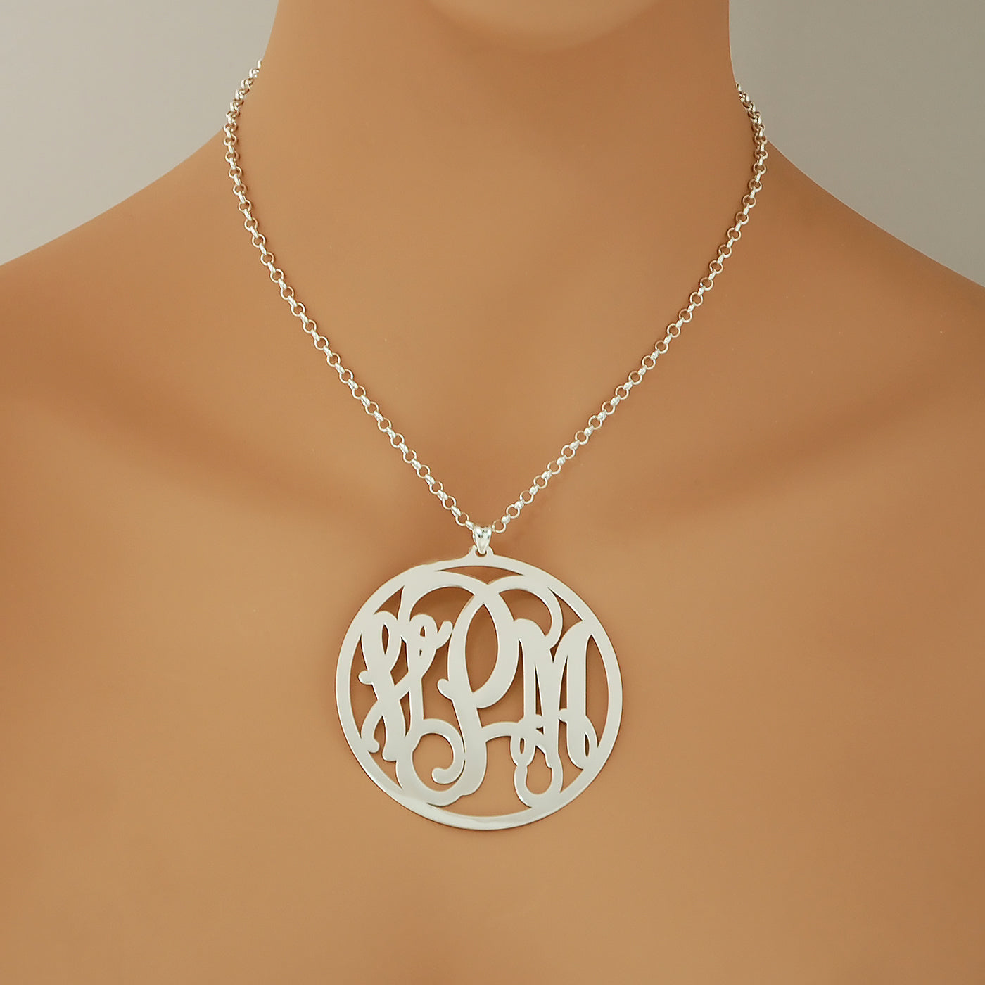 Woman wearing a personalized 2.5-inch sterling silver circle monogram pendant necklace.