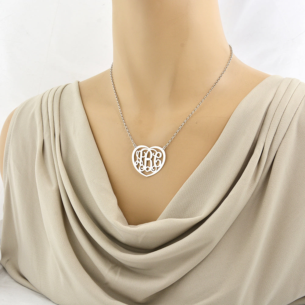 Woman wearing a personalized sterling silver heart monogram necklace with a 3-initial custom pendant.