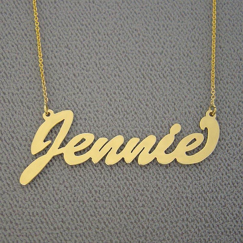 Close-up of a custom brushed gold cursive script nameplate pendant showing hand-finished texture.