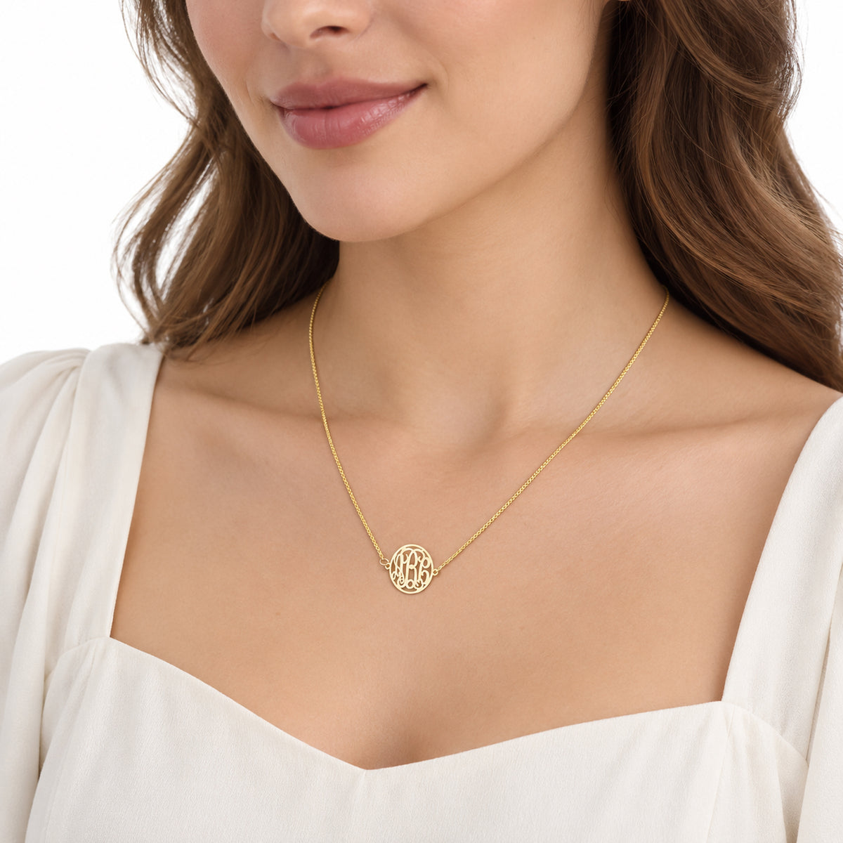Close-up of a woman wearing a personalized solid gold circle monogram necklace