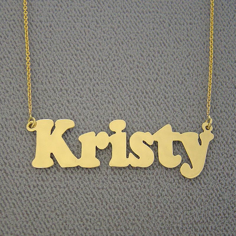 Custom solid gold nameplate necklace with bold print letters spelling Kristy displayed on a background.