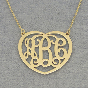 Close-up of a custom laser-cut 3-initial heart monogram pendant in solid gold.