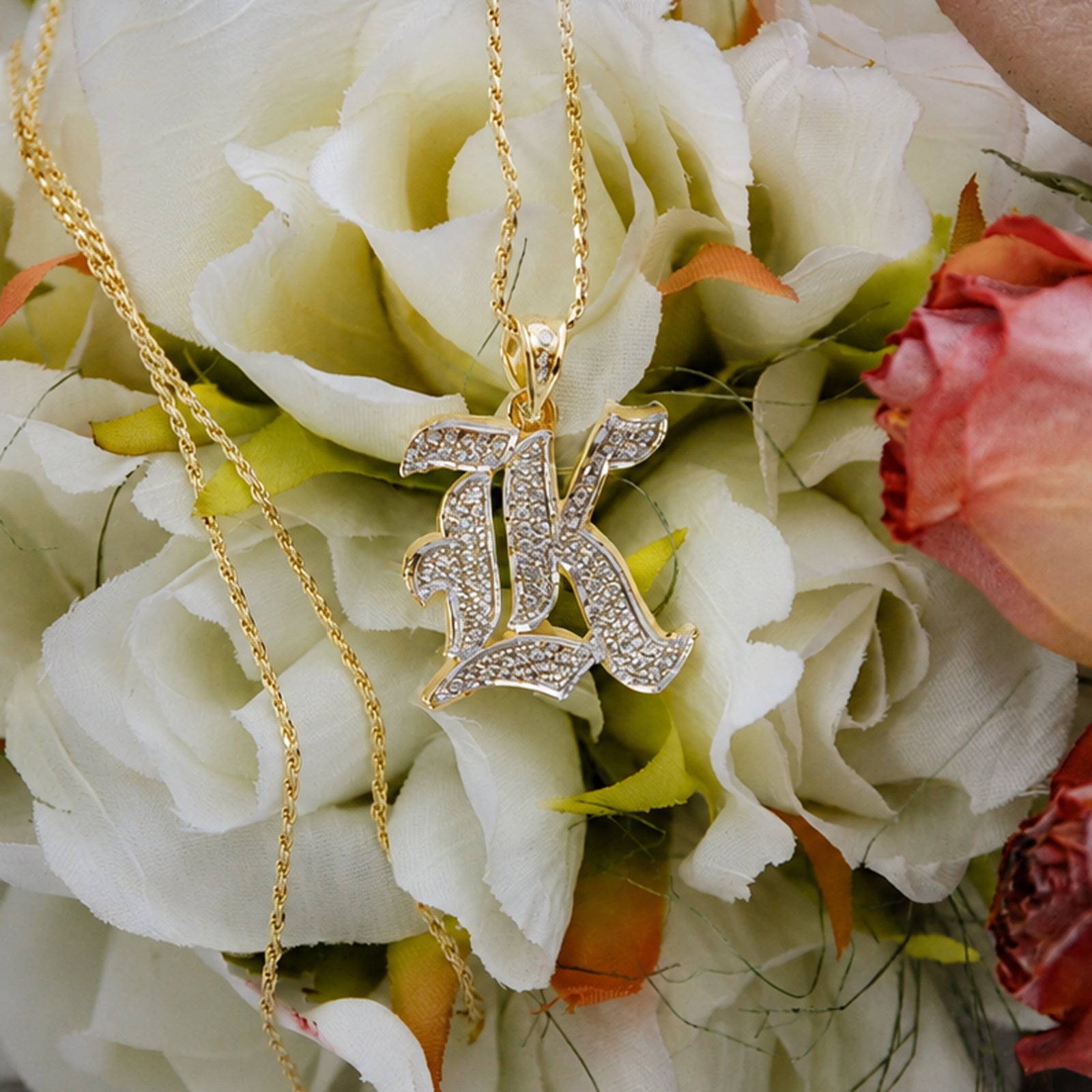Hand-engraved 3D solid gold Old English initial charm styled with fine jewelry accessories.