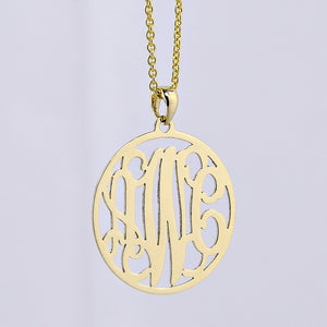 Custom solid gold 3-initial monogram pendant necklace on a delicate gold chain against a light gray background.