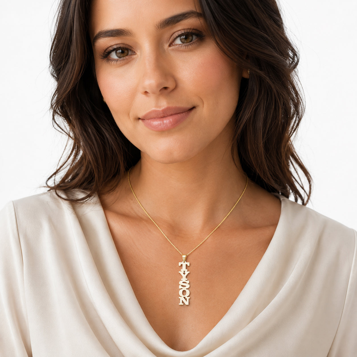 Model wearing a solid gold custom vertical block letter nameplate pendant TYSON