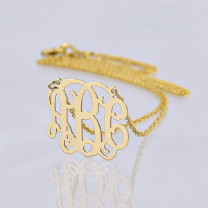 Detailed view of a personalized 3-initial solid gold monogram necklace