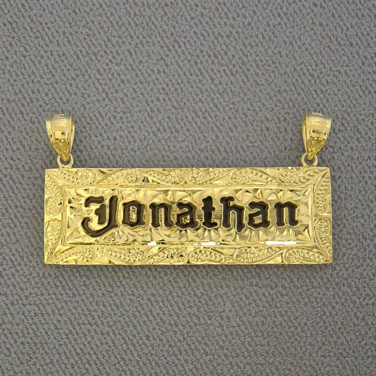 Custom solid 14k yellow gold Hawaiian heirloom name pendant featuring hand-engraved scrollwork and black enamel lettering reading 'Jonathan'.