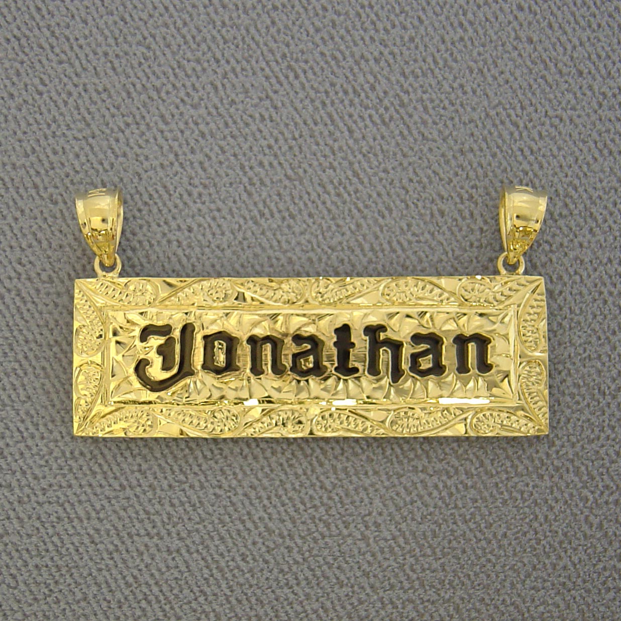 Custom solid 14k yellow gold Hawaiian heirloom name pendant featuring hand-engraved scrollwork and black enamel lettering reading 'Jonathan'.