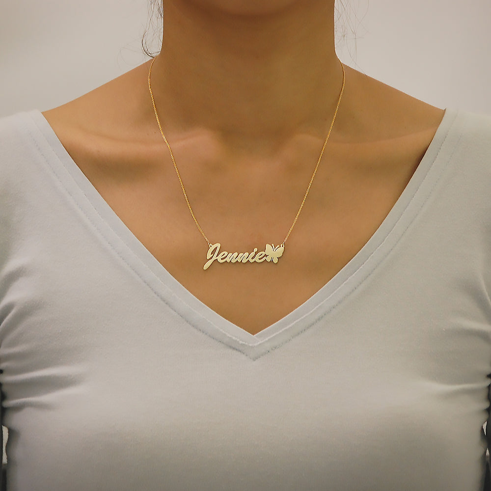 Custom solid gold name necklace spelling Jennie with a butterfly accent worn on a model