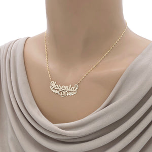 Model wearing the custom 10K/14K gold Sweet 16 name necklace with wings and heart pendant.