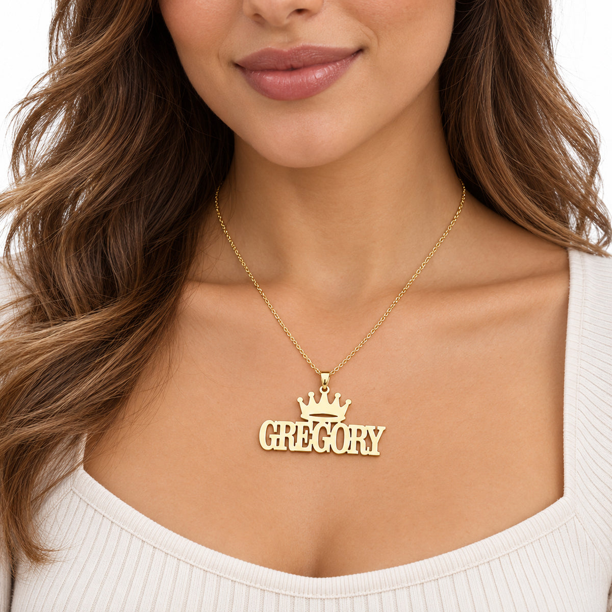 Woman wearing a personalized yellow gold crown nameplate necklace with Gregory in block letters
