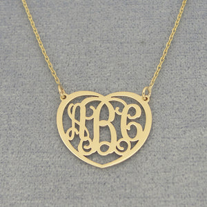 Close-up of laser-cut solid gold 3-initial heart monogram pendant