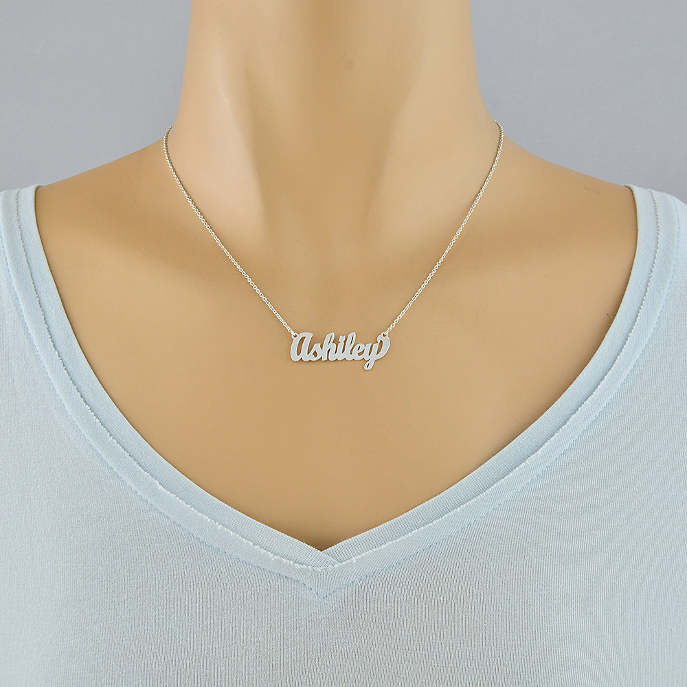 Model wearing a small sterling silver personalized cursive name necklace styled as a choker.