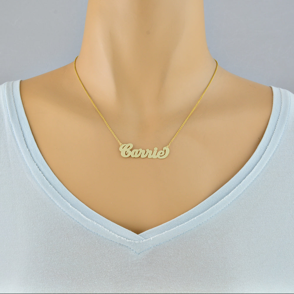 Model wearing a small personalized solid gold script nameplate necklace.