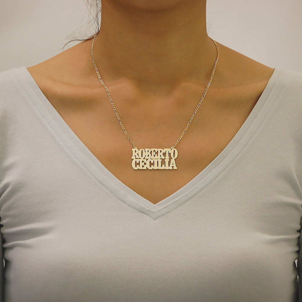 Model wearing a personalized solid gold two name nameplate necklace on an 18-inch Figaro chain.