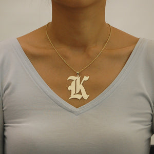Model wearing solid gold Gothic initial pendant charm on a gold rope chain