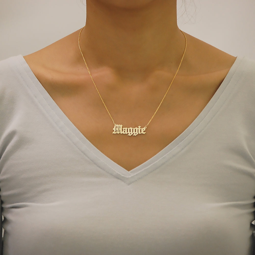 Model wearing a handcrafted solid gold Old English Gothic custom nameplate necklace.