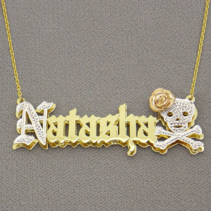 Close-up detail of the custom nameplate pendant showing diamond-cut rhodium accents on the skull and Old English lettering.
