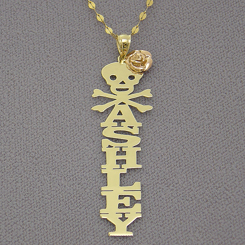 Personalized 10k yellow gold vertical name pendant featuring custom block lettering with a rose gold flower, skull, and crossbones top emblem.