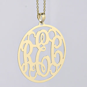 Close-up detail showing the thickness and polished finish of a custom solid gold circle monogram pendant
