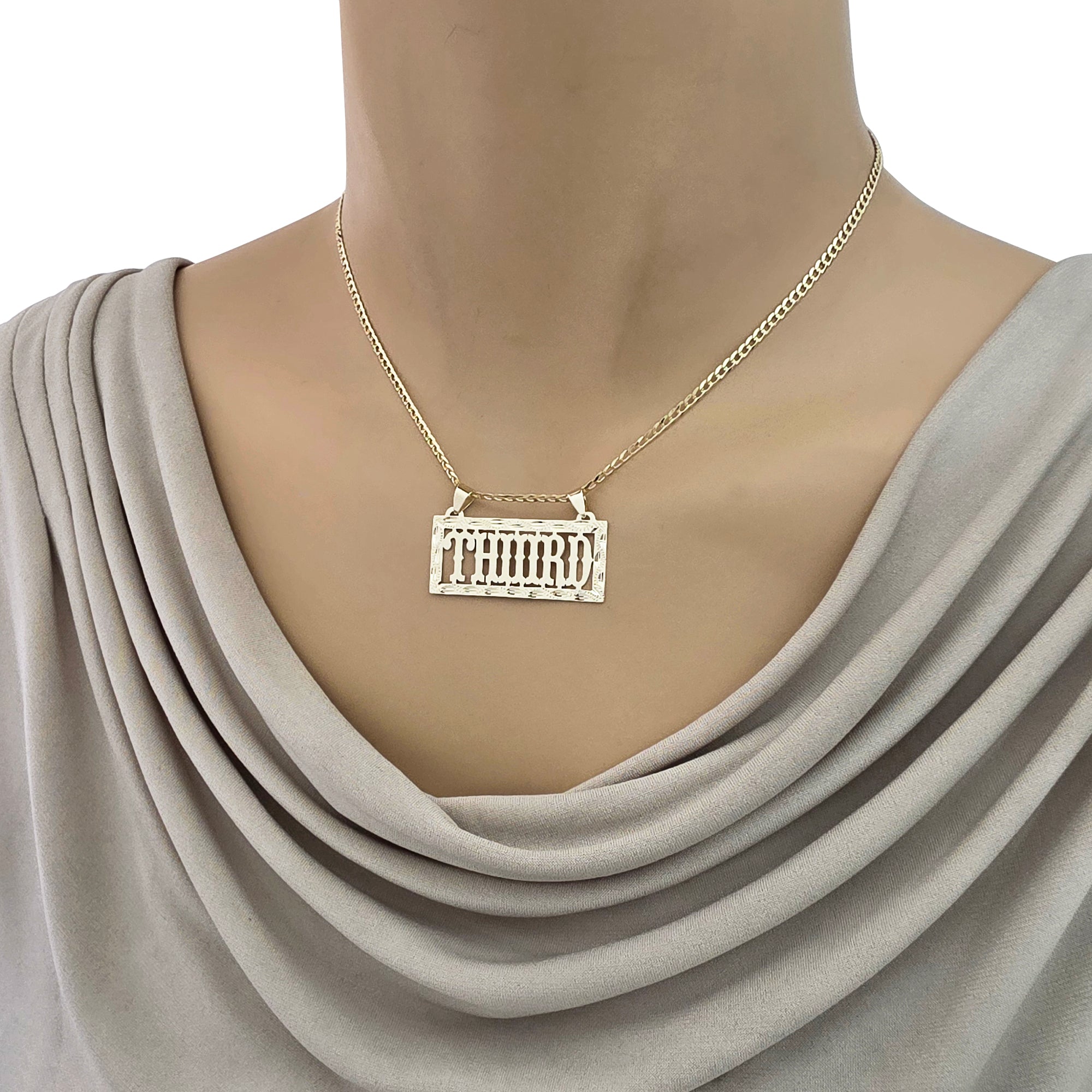 Close-up view of a custom gold rectangular name pendant styled on a mannequin chain.