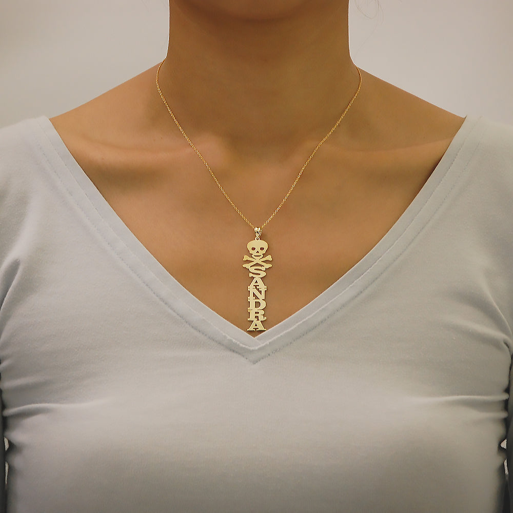 Woman wearing personalized solid gold vertical name pendant attached to a fine gold chain around the neck