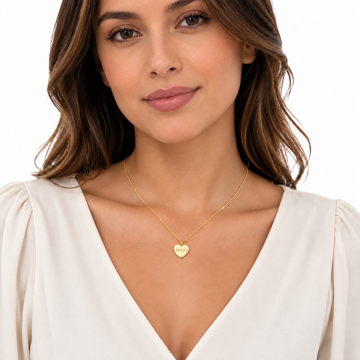 Woman wearing a personalized solid yellow gold heart pendant necklace with laser-engraved name