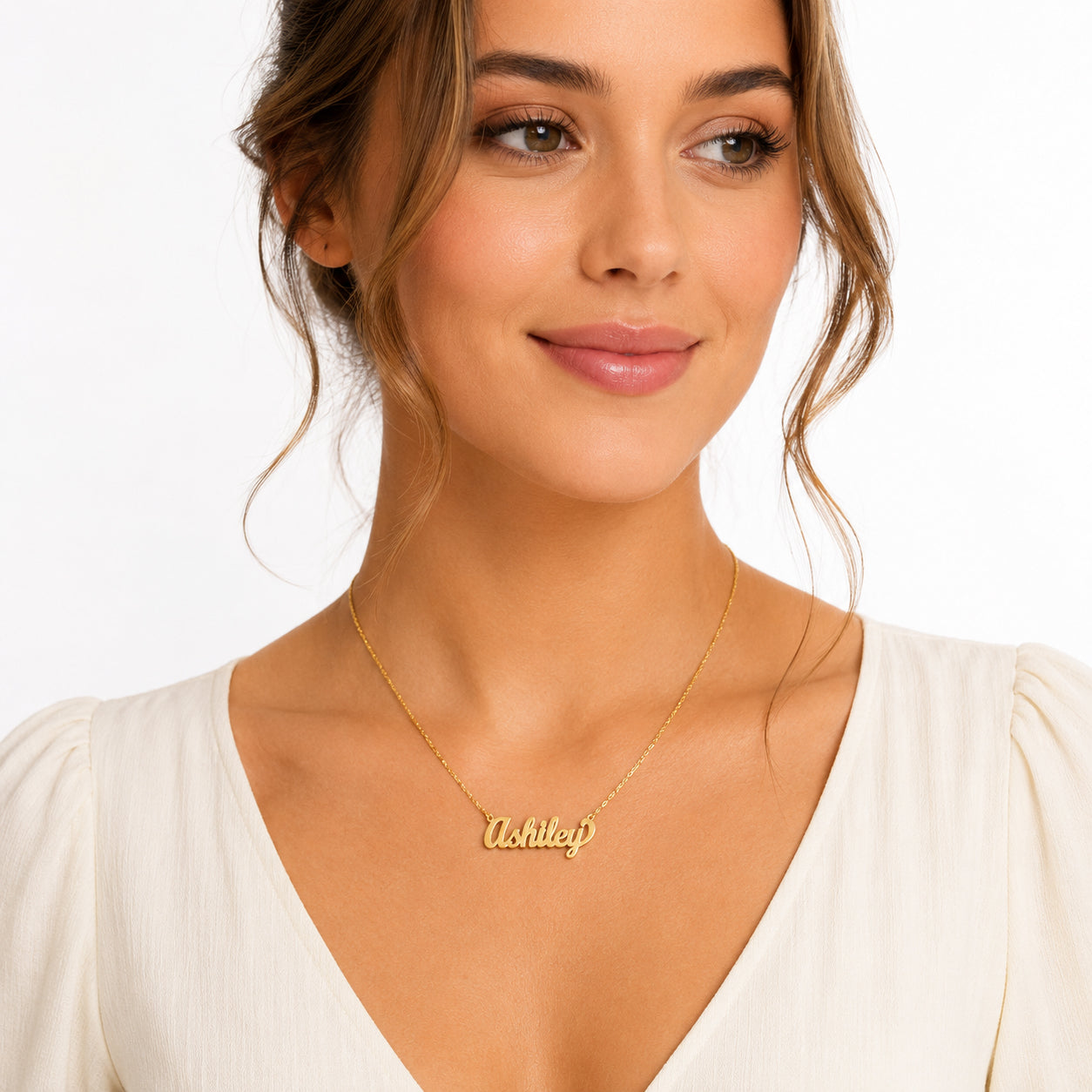 Woman wearing a small 14k gold cursive nameplate necklace spelling Ashley on a Singapore gold chain