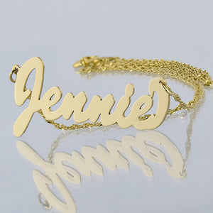 Small 10k or 14k yellow gold personalized script nameplate necklace featuring custom cursive lettering for the name Jennie on a gold chain.