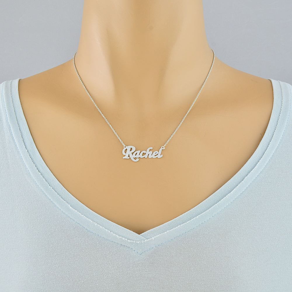 Model wearing a small personalized sterling silver script nameplate necklace hanging on a 15–16 inch Rolo chain.